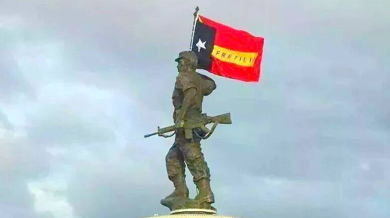 A statue depicts Nicolau dos Reis Lobato holding an east timorese flag