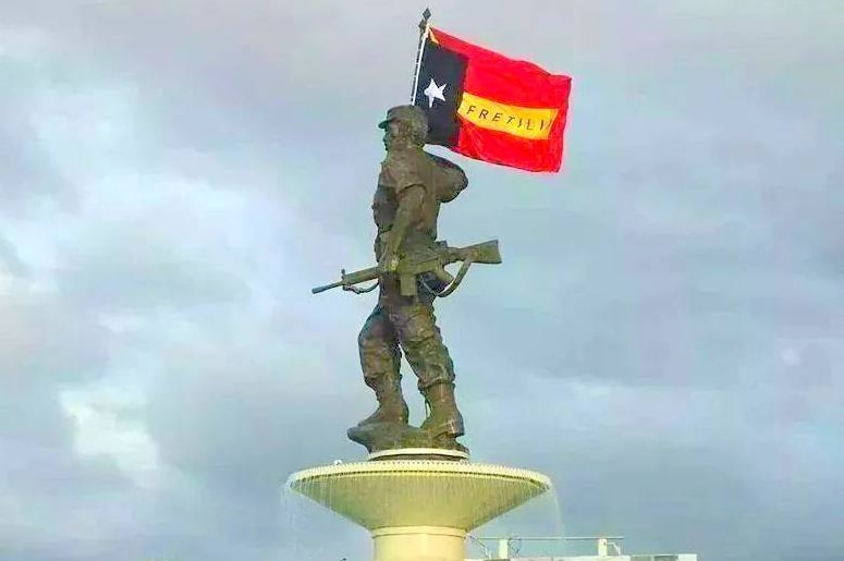 A statue depicts Nicolau dos Reis Lobato holding an east timorese flag