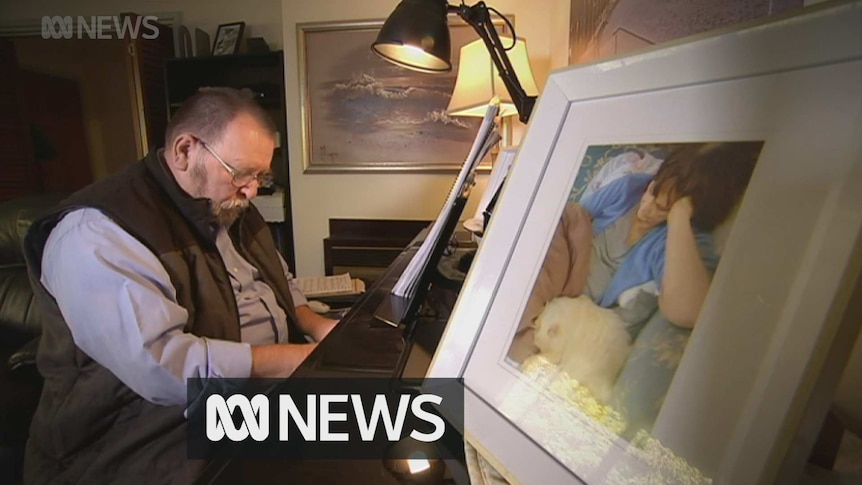 Euthanasia advocate John Paynter plays piano next to a photo of his late wife Mary Ann who died of cancer