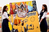 Sotheby's employees carry Orange Sports Figure, by Jean-Michel Basquiat.