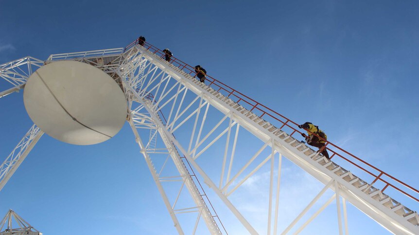 Workers climbing the 70 metre antenna at the Canberra Deep Space Communication Complex site at Tidbinbilla.