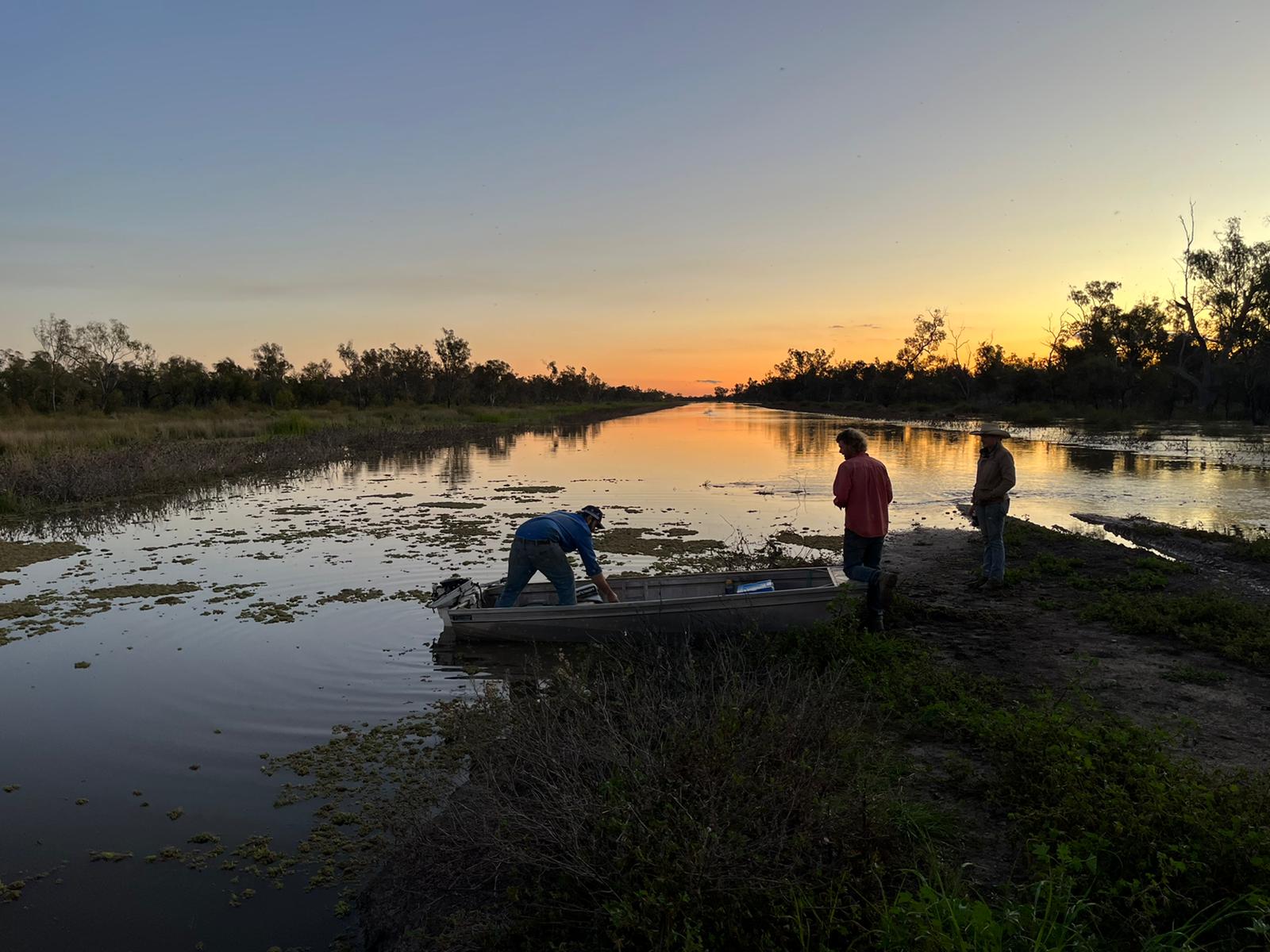 A flooded farm with farmers boating across 