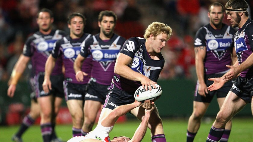 Aiden Tolman of the Storm tries to hold onto the ball under pressure from Matt Prior of the Dragons.