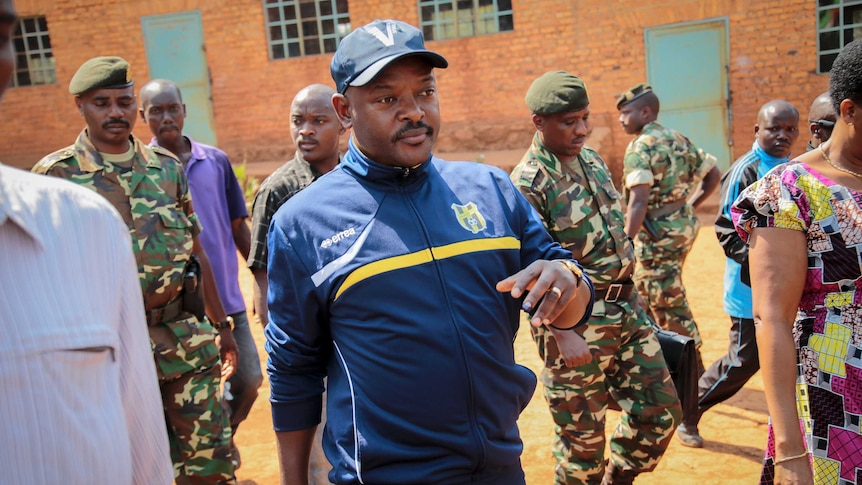 Burundi's President Pierre Nkurunziza walks to a polling station to cast his vote dressed in a blue tracksuit and cap.