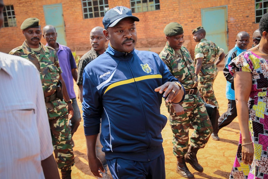 Burundi's President Pierre Nkurunziza walks to a polling station to cast his vote dressed in a blue tracksuit and cap.
