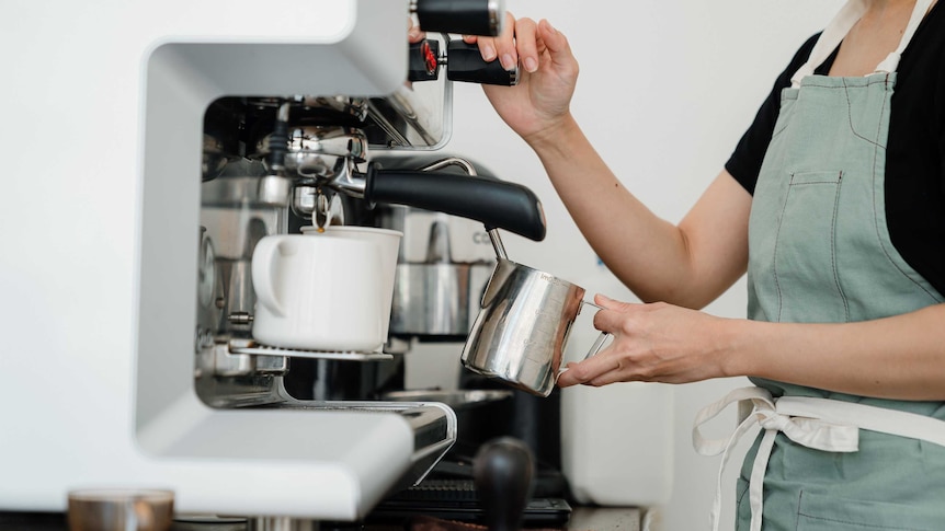 Woman making coffee on an espresso machine