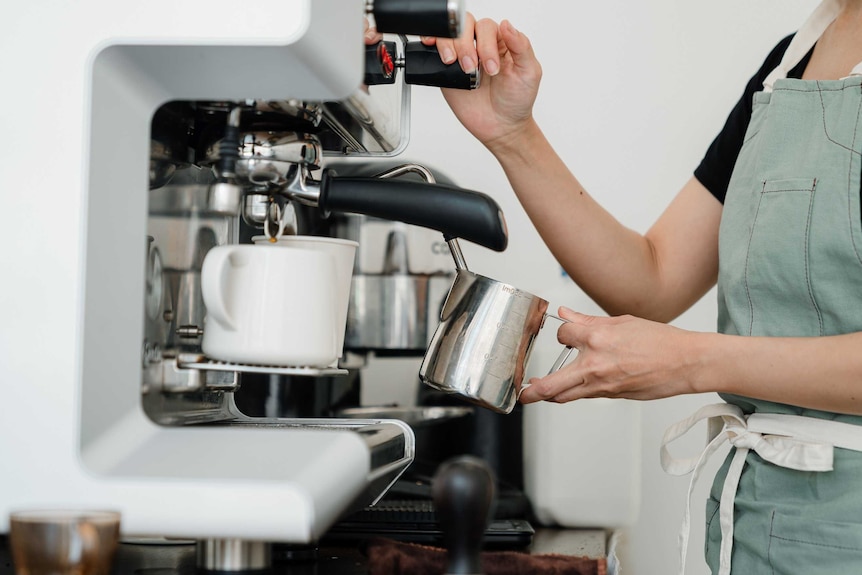 Woman making coffee on an espresso machine