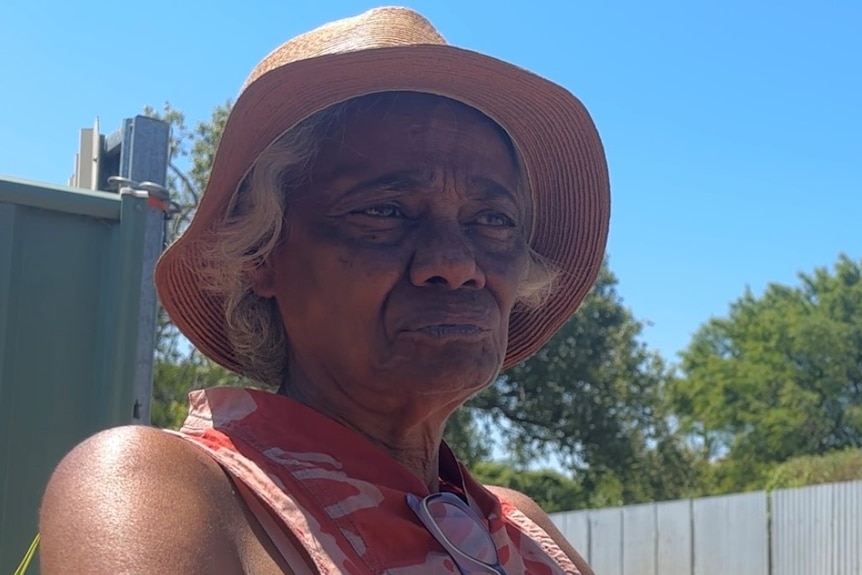 A Gamilaroi woman looks off camera in the midday sun of Moree. 