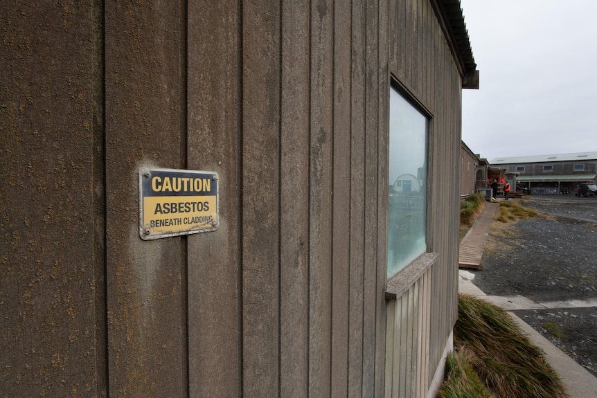 Asbestos warning sign on a wooden building.
