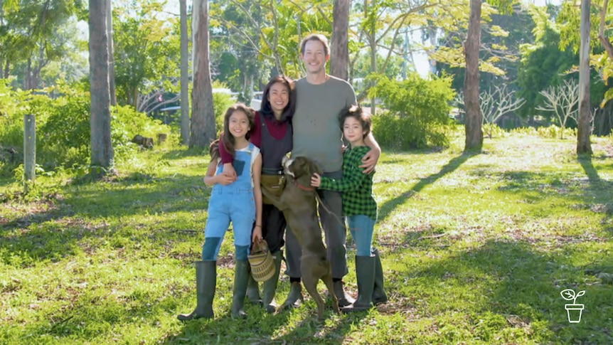 Family with dog standing in garden for portrait photo