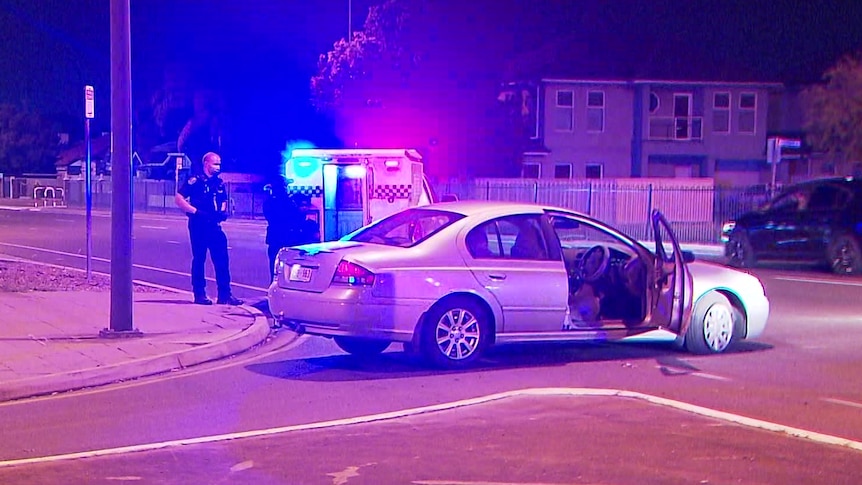 A sedan next to a police wagon