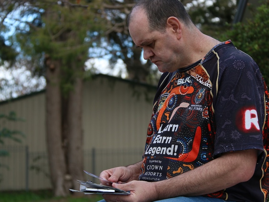 A man looks at photos of his son.