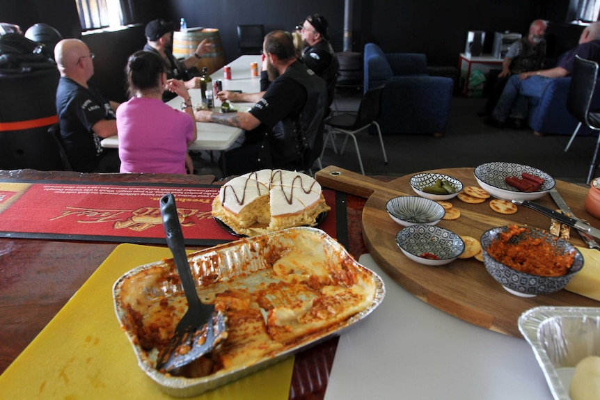 Lasagne, chips and dip and a cake on a table.