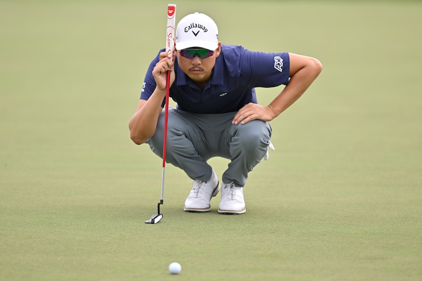 Min Woo Lee lines up a putt at a PGA Tour event in Florida.