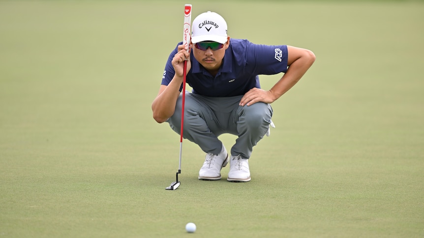 Min Woo Lee lines up a putt at a PGA Tour event in Florida.