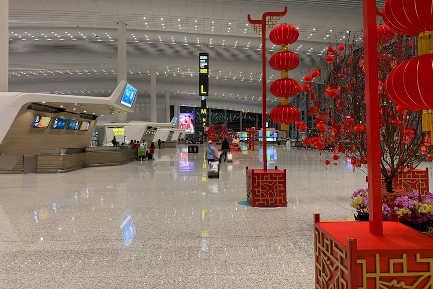 Inside an almost empty airport decorated with some red Lunar New Year decorations.