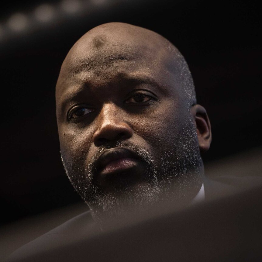 Gambia's Justice Minister Aboubacarr Tambadou is seen dressed in a suit with a dark background.