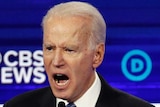 Former Vice President Joe Biden speaks loudly on the debate stage.