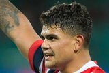 Latrell Mitchell points a finger on his raised right arm as he celebrates the Roosters' win over the Tigers.