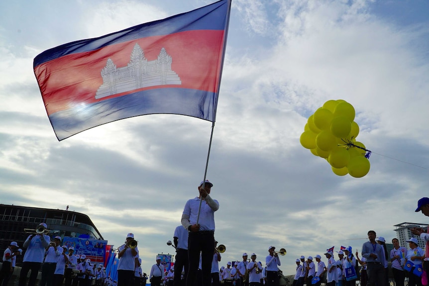 A man waves a flag at a rally supporting the governing Cambodian People's Party in Phnom Penh on July 27, 2018.