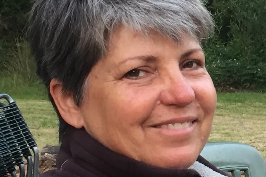 A smiling woman with greying hair.