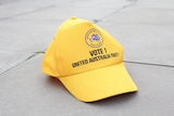 A photo of a yellow hat with the United Australia Party symbol on the front