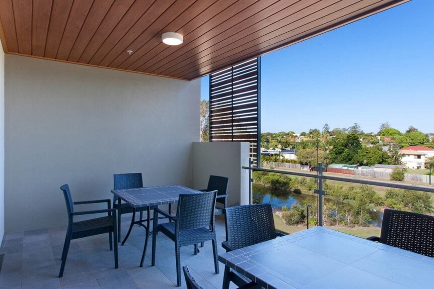 Tables and chairs on a balcony at a unit complex.