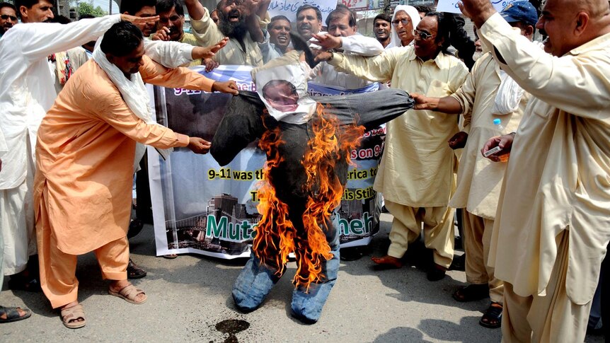 Pakistani activists burn an effigy of former US president George W Bush