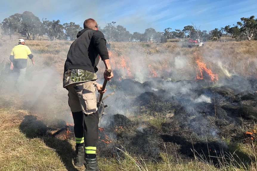 Man tends grass fire