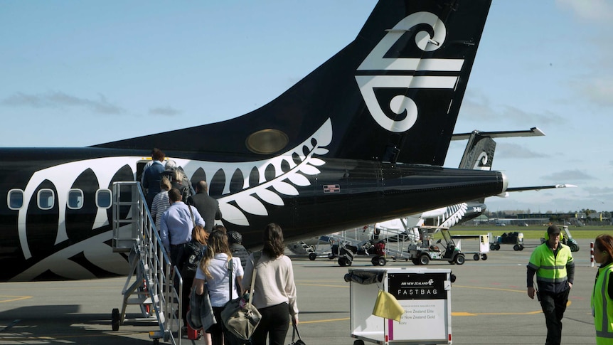 People board a Air New Zealand plane on a tarmac