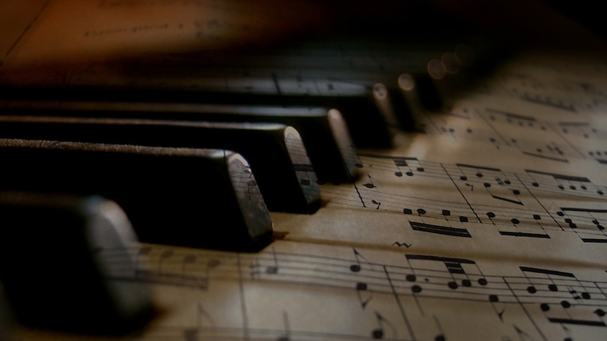 Sheet music overlayed on piano keys.
