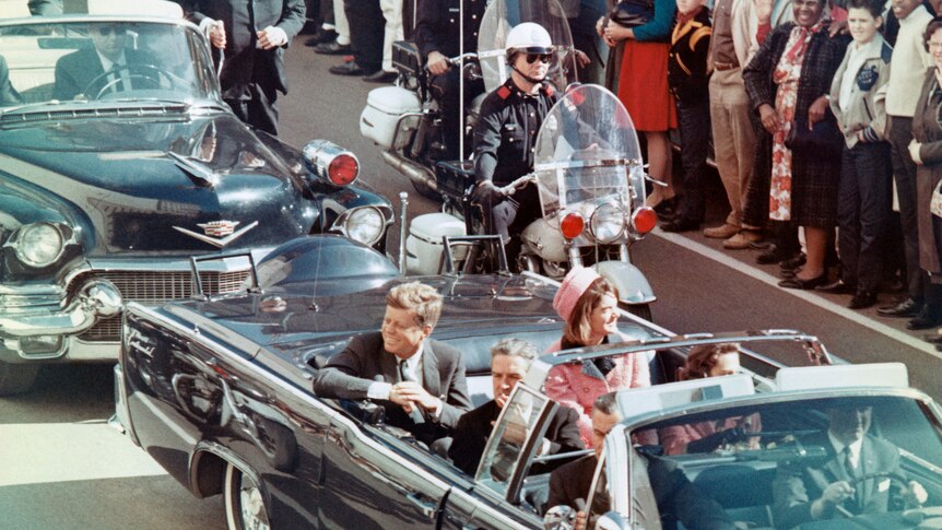 president kennedy with Jacqueline Kennedy and texas governor Connally, smiling at crowd from convertible