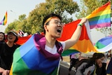 Young people wearing the rainbow flags are walking on the street of Nanjing city.