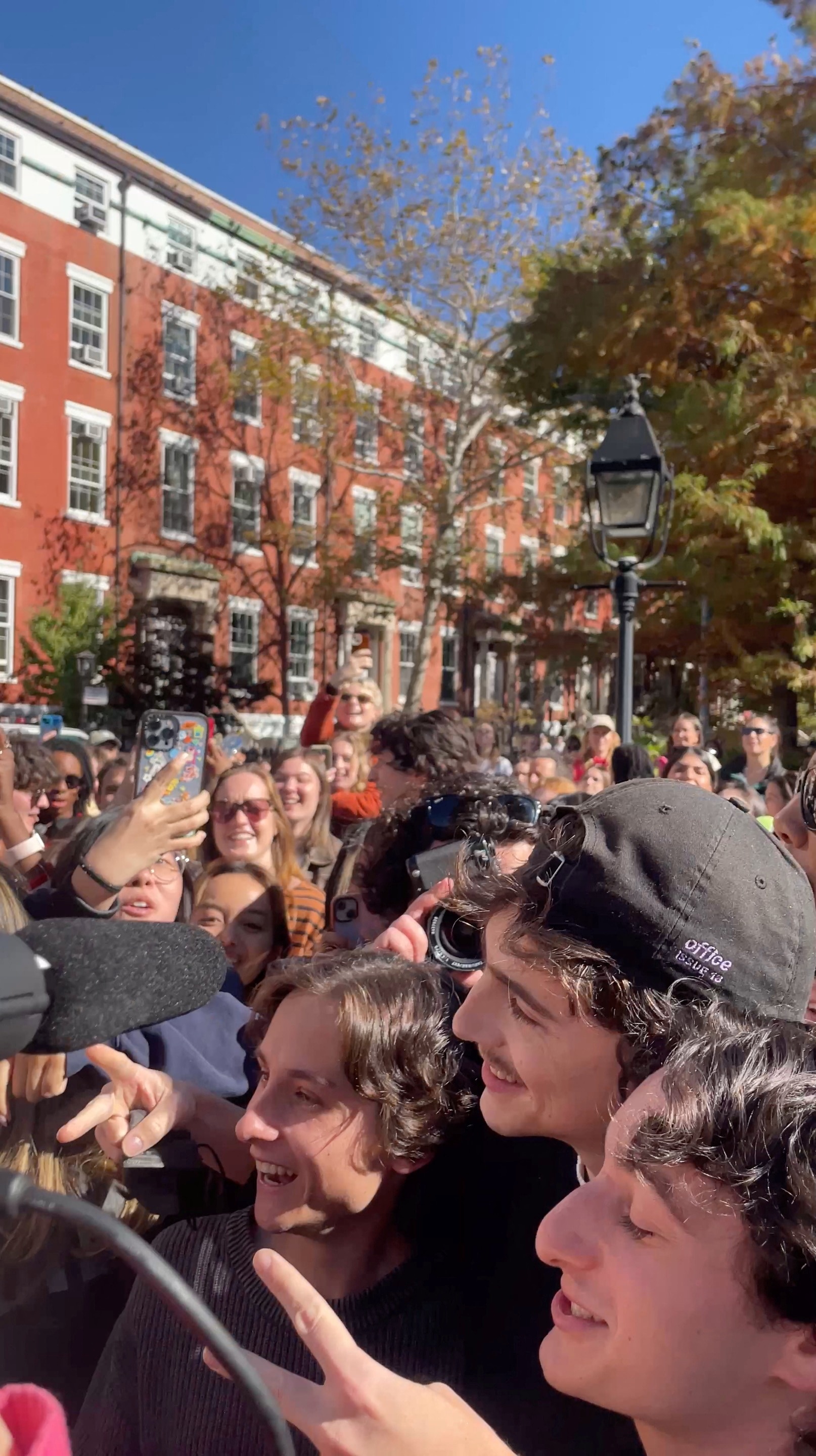 A crowd of people trying to take a photo with Timothee Chalamet