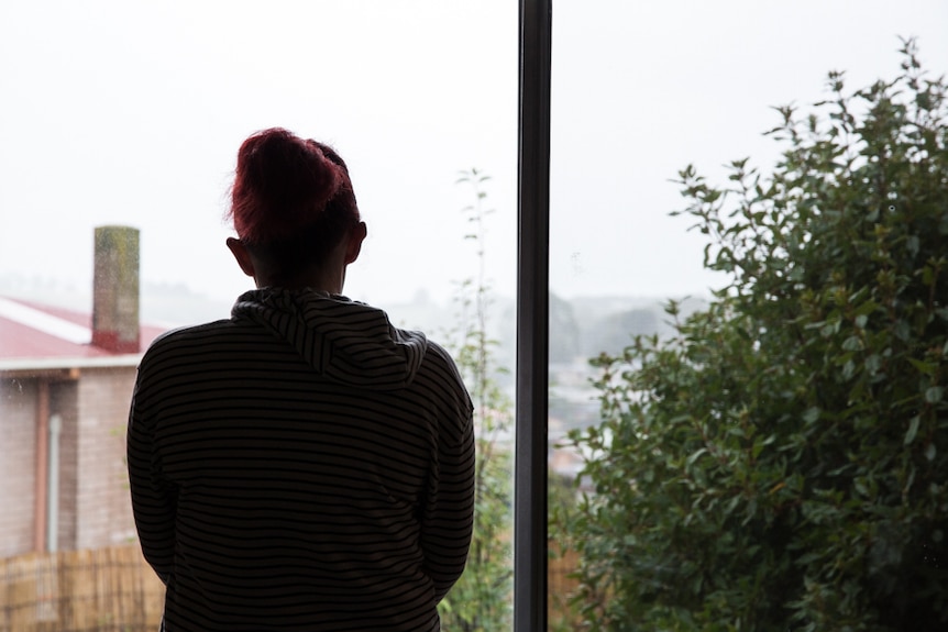 Mum-of-four Mary looks out a window, she has been couch surfing since February with three of her children.