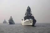 Three Indian warships sailing in a line.