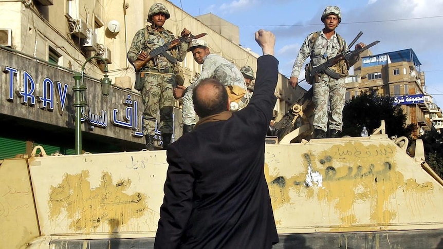 A protester raises his fist in front of an Egyptian Army armoured personnel carrier