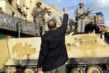 A protester raises his fist in front of an Egyptian Army armoured personnel carrier