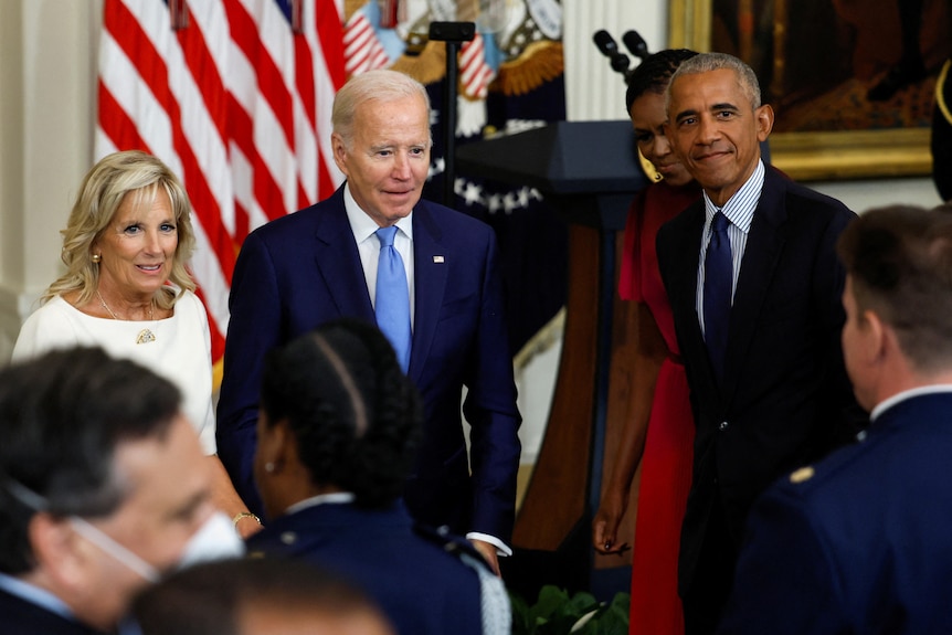 Jill Biden, Joe Biden, Michelle Obama and Barack Obama standing in front of a crowd. 