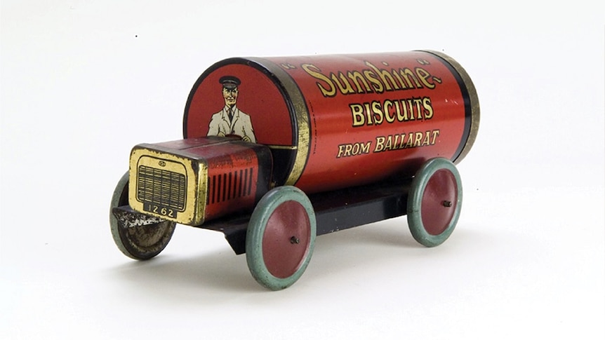 An old red and gold Sunshine biscuits tin turned into a toy car