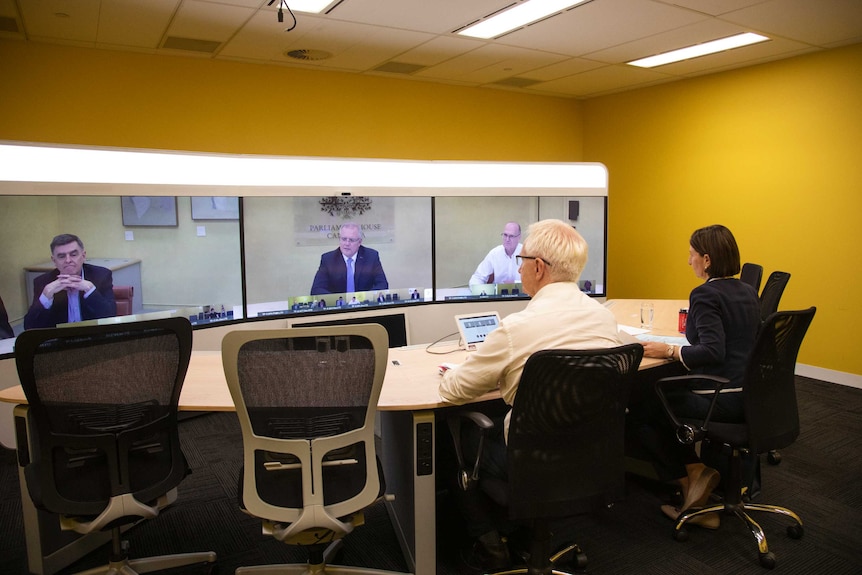 Gladys Berejiklian and Tim Reardon sit in a yellow room looking at screens with Scott Morrison, Brendan Murphy and Phil Gaetjens