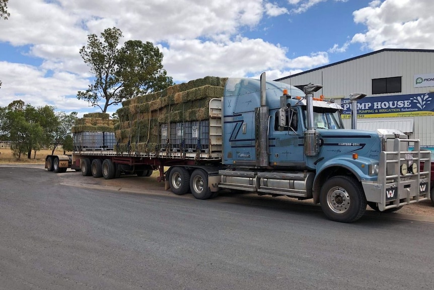 A truck carrying hay bales.