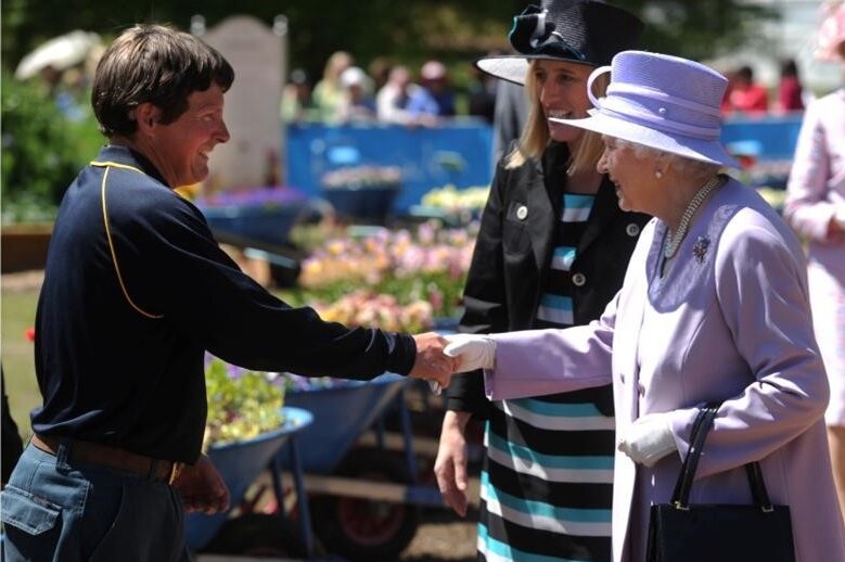 A gardener shakes hands with the Queen at Floriade