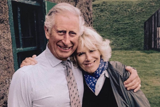 Charles and Camilla grin and embrace 