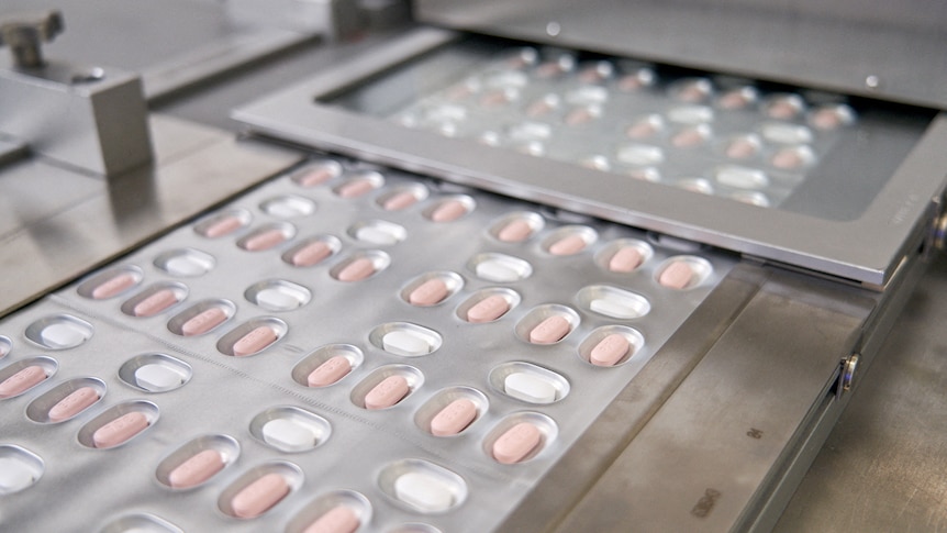 Pfizer's new COVID pills in their packaging coming out of the production line.
