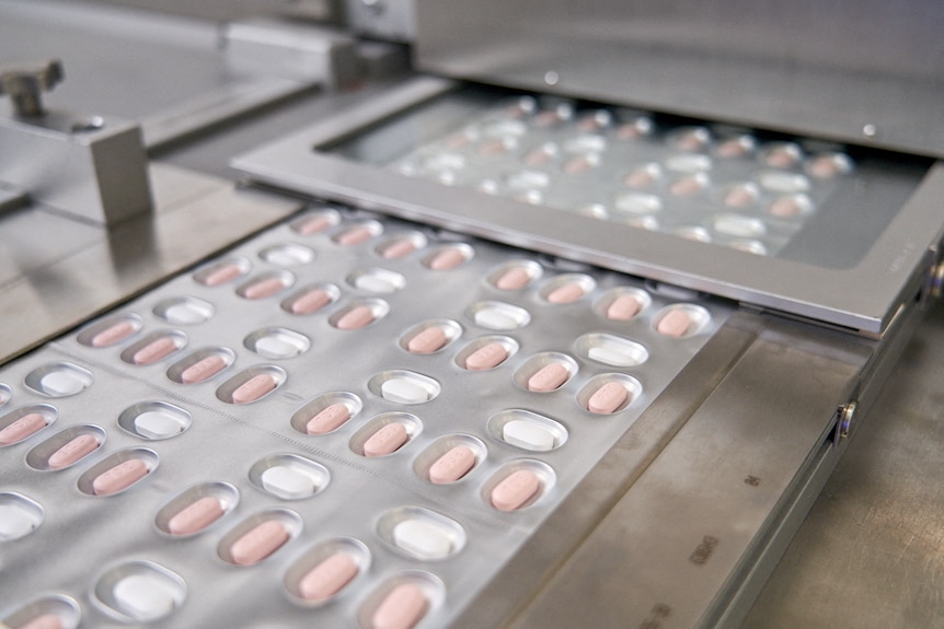 Pfizer's new COVID pills in their packaging coming out of the production line.