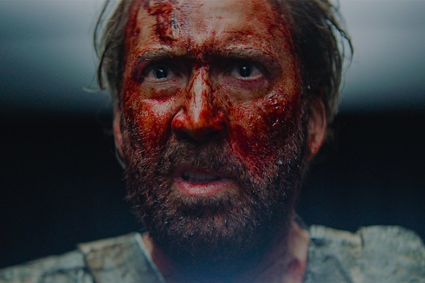Close-up colour still of Nicholas Cage's face covered in blood in 2018 film Mandy.