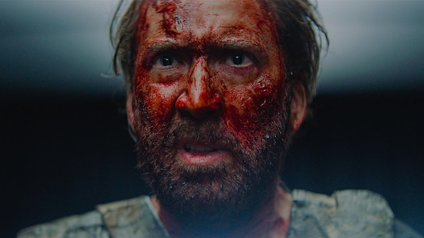 Close-up colour still of Nicholas Cage's face covered in blood in 2018 film Mandy.