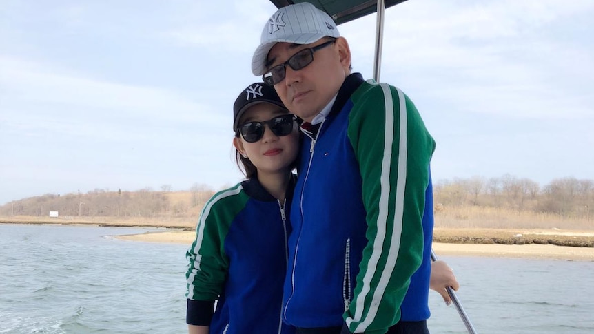 Xiaoliang Yuan and Yang Hengjun stand close together on a boat.