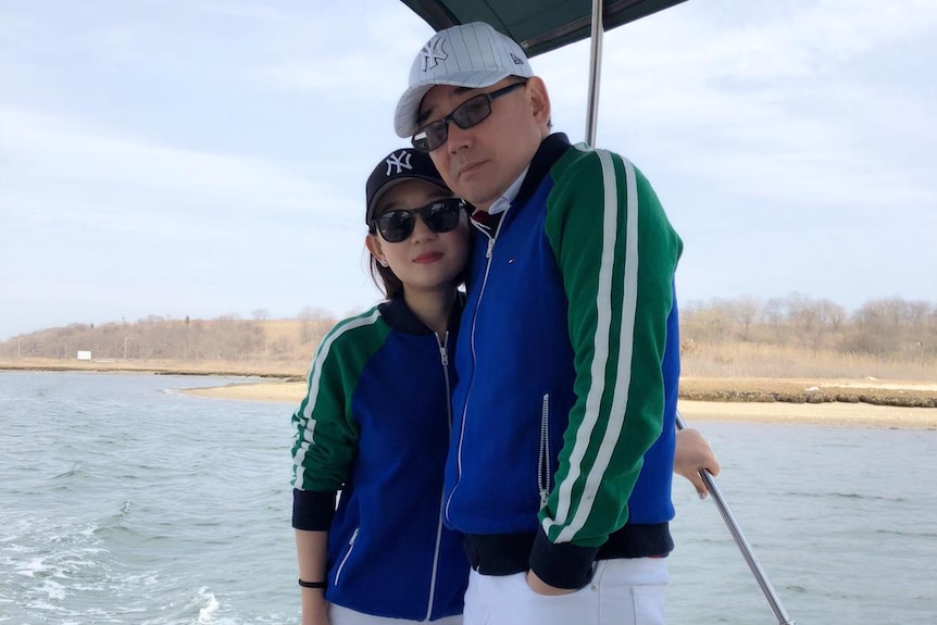 Yuan Xiaoliang and Yang Hengjun on a boat, wearing sunglasses.